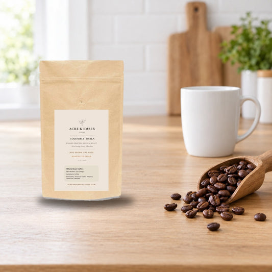 Acre & Ember Colombia Huila washed whole bean coffee bag on a bright kitchen counter with a scoop of roasted beans